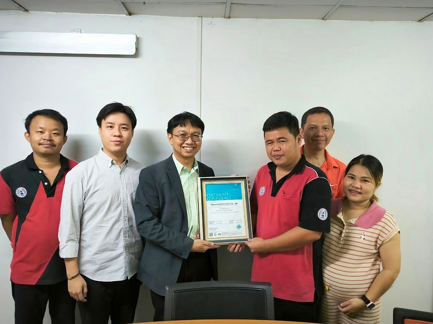 ผู้แทน Equal Assurance (Thailand) ส่งมอบใบรับรองให้ผู้บริหารโรงงานในห้องประชุม