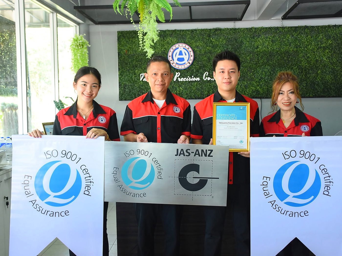 พนักงานโรงงานถือป้าย ISO 9001 certified ในวันรับใบรับรองจาก Equal Assurance